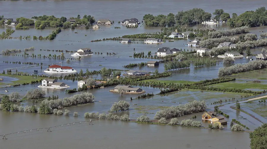Aerial view of homes and farmland surrounded by river floodwater in the Missouri River valley